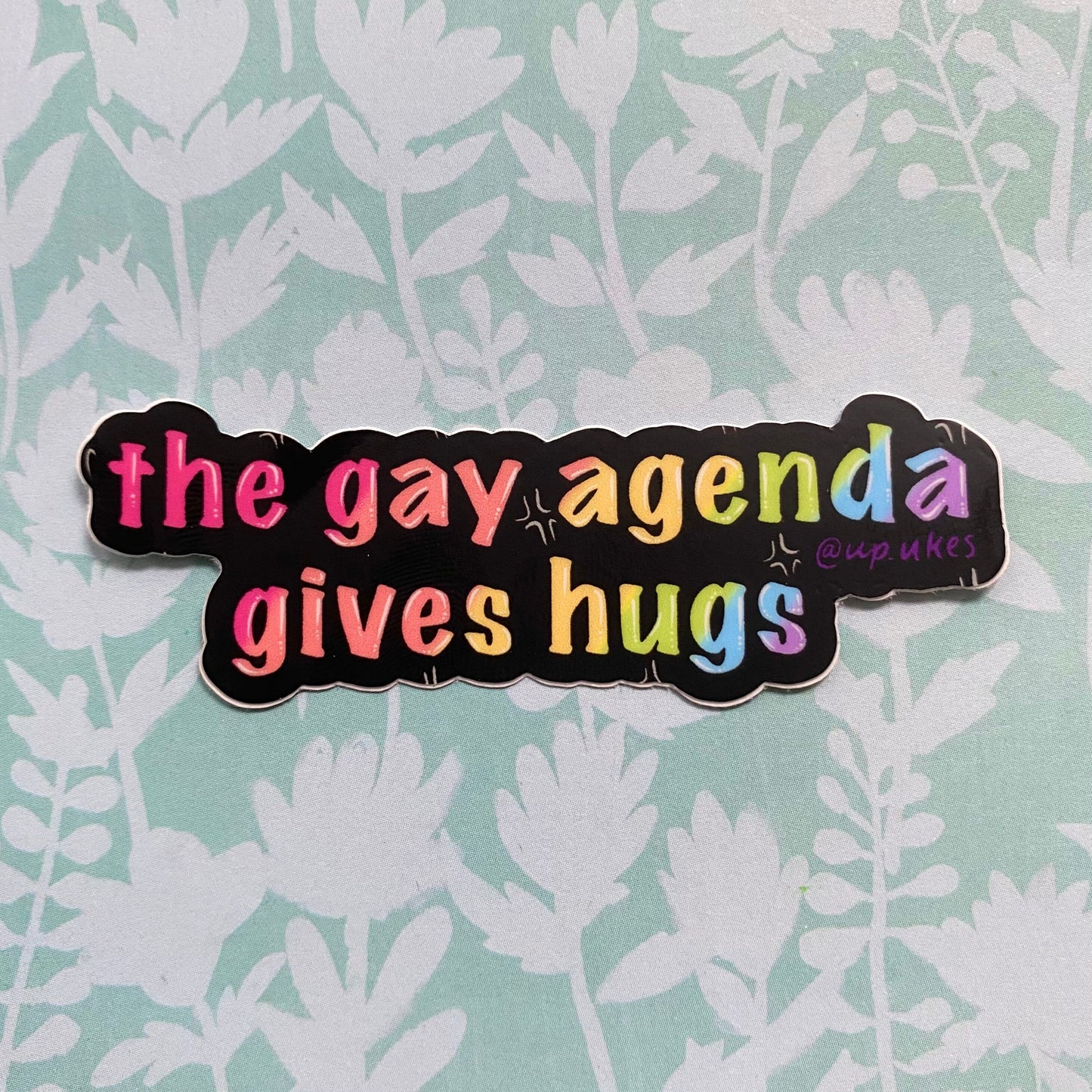 The Gay Agenda Gives Hugs Sticker, 3”x1”